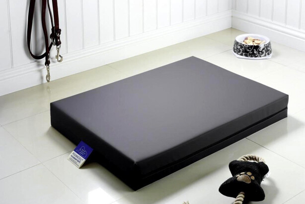 Ein dunkelgraues Hundebett der Serie PULMACELL safe von MEDI-TECH, das auf einem Fliesenboden liegt.